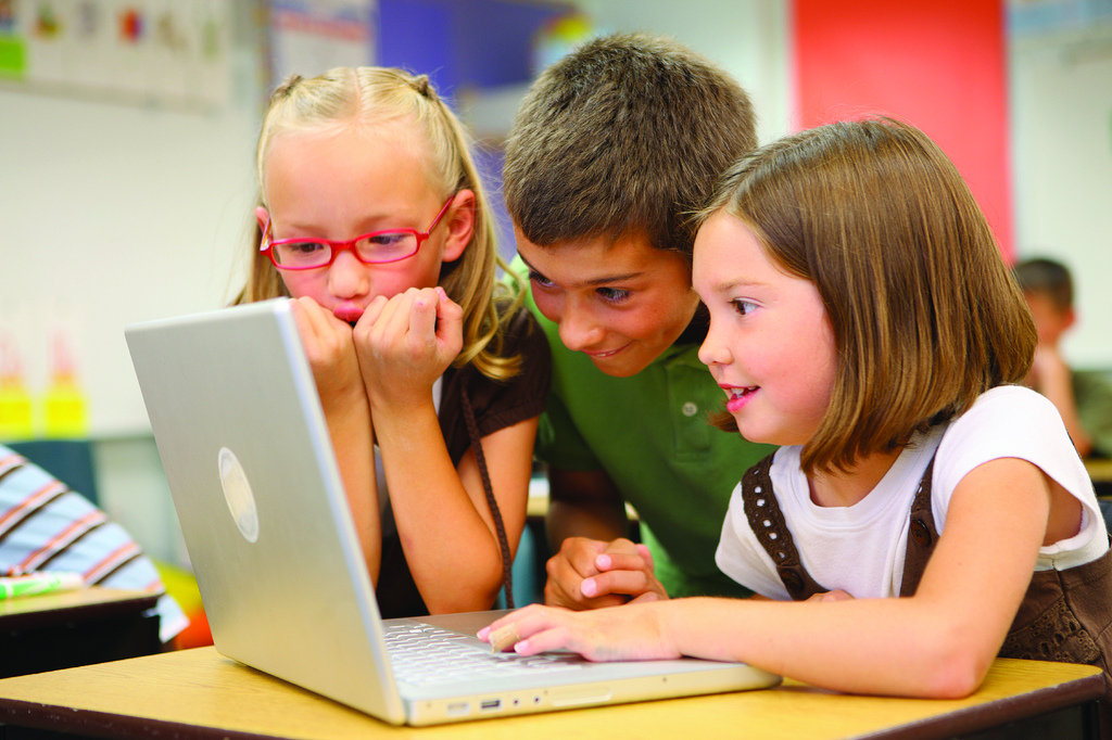 Excited looking kids at a laptop